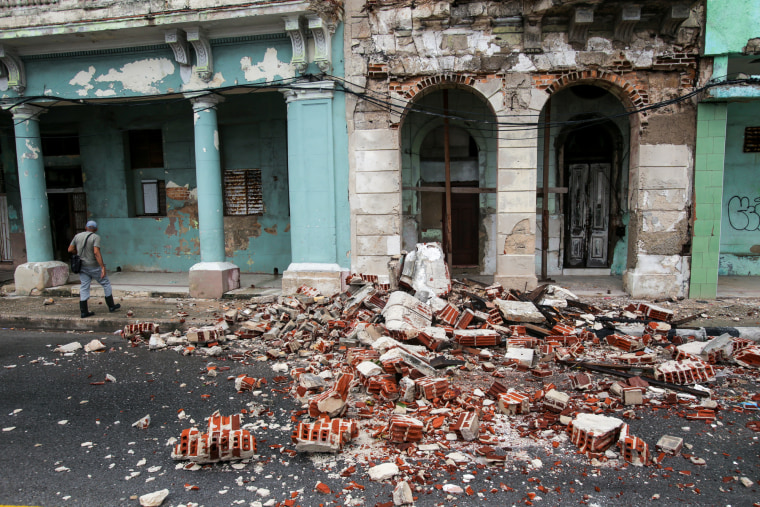 Debris surrounds a damaged building