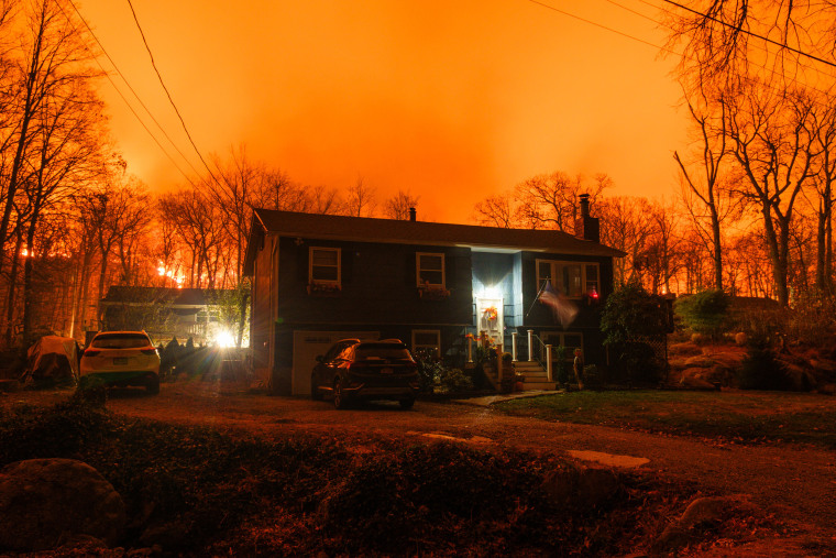 A long exposure photograph of the Jennings Creek wildfire burning behind a home in Greenwood Lake