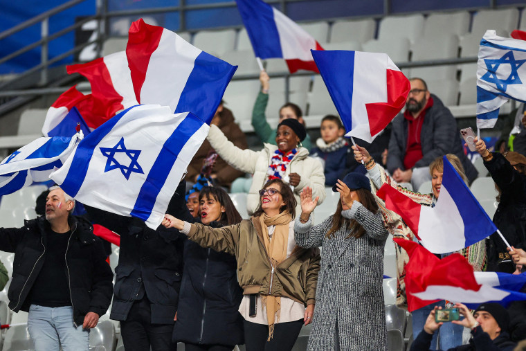 French and Israeli supporters wave flags.