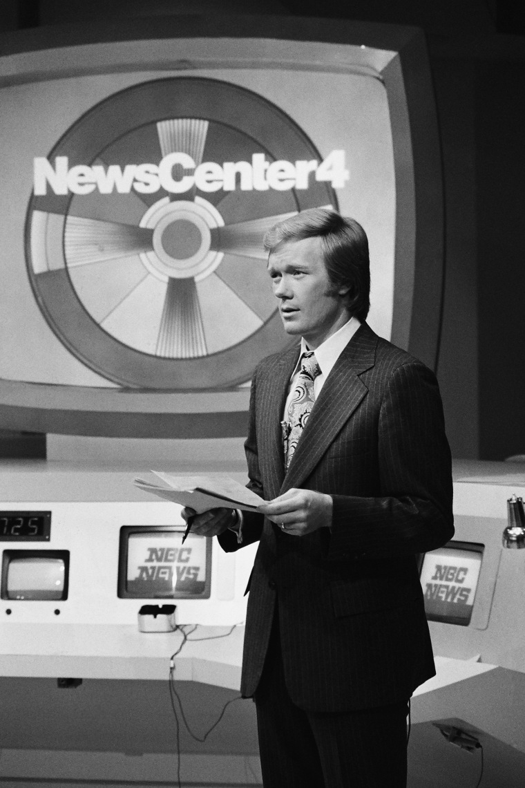 Uma foto em preto e branco de Chuck Scarborough em frente à placa do News Center 4