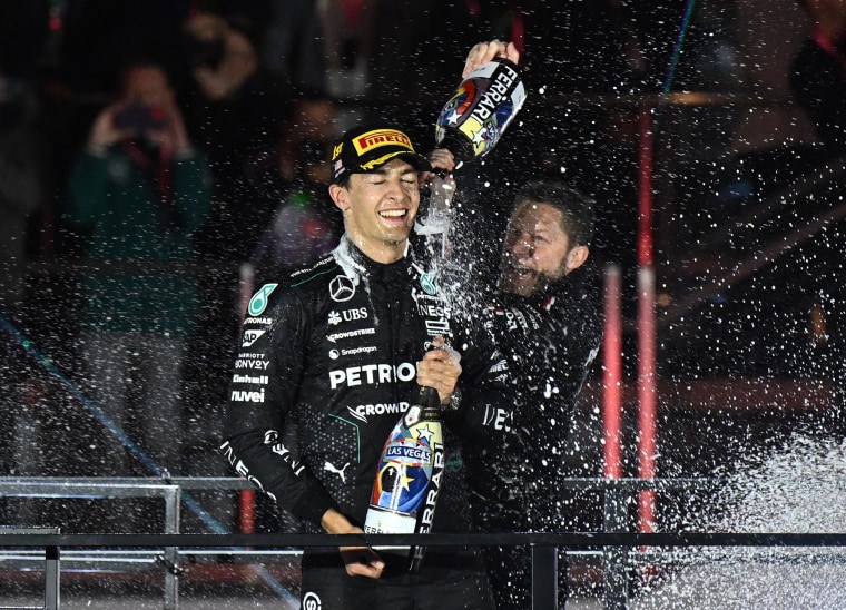 Mercedes' British driver George Russell celebrates on the podium 