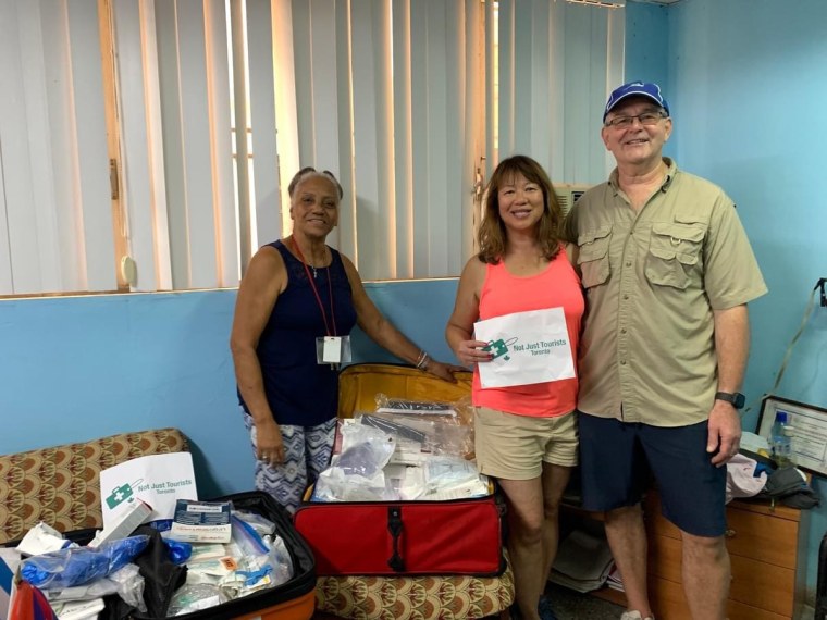 Una pareja de vacaciones lleva una maleta con suministros médicos a un destino en Cuba.