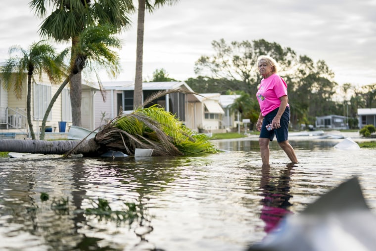  A woman walks along a flooded street.