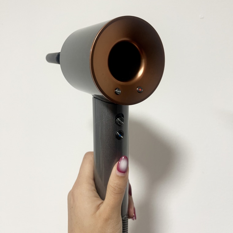 Woman holds Dyson Supersonic Hair Dryer in her hands.