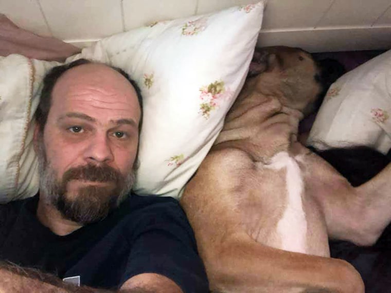 Michael Naylor and his dog Minnie in bed.