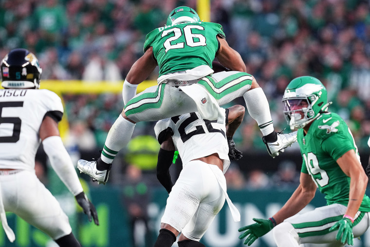 Saquon Barkley #26 of the Philadelphia Eagles tackles Jarrian Jones #22 of the Jacksonville Jaguars.