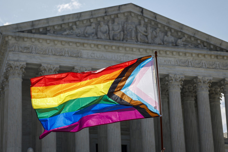 A person waves LGBTQ flag.