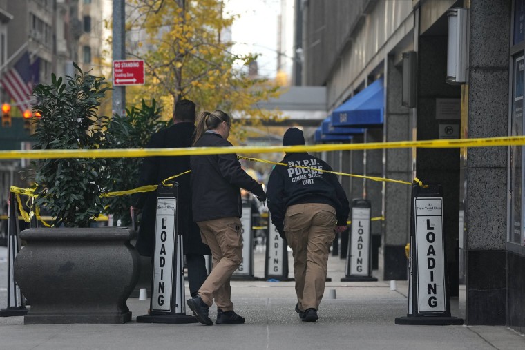 Police cover evidence with paper cups at the scene where UnitedHealthCare CEO Brian Thompson was shot as he entered the New York Hilton on Dec. 4, 2024.