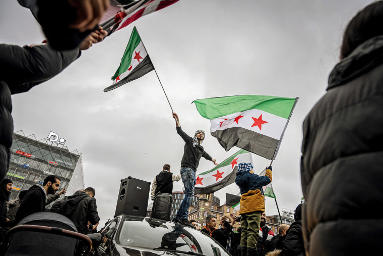 Members of the Syrian community wave Syrian opposition flags on Dec. 8, 2024 in Copenhagen, Denmark.