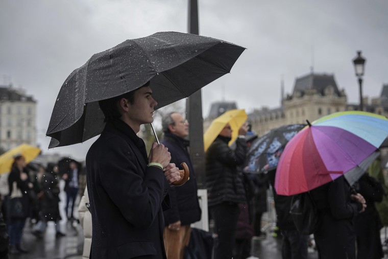 Spectators watch the Mass on a screen outside Notre Dame Cathedral Sunday, Dec. 8, 2024 in Paris for it's formal reopening.