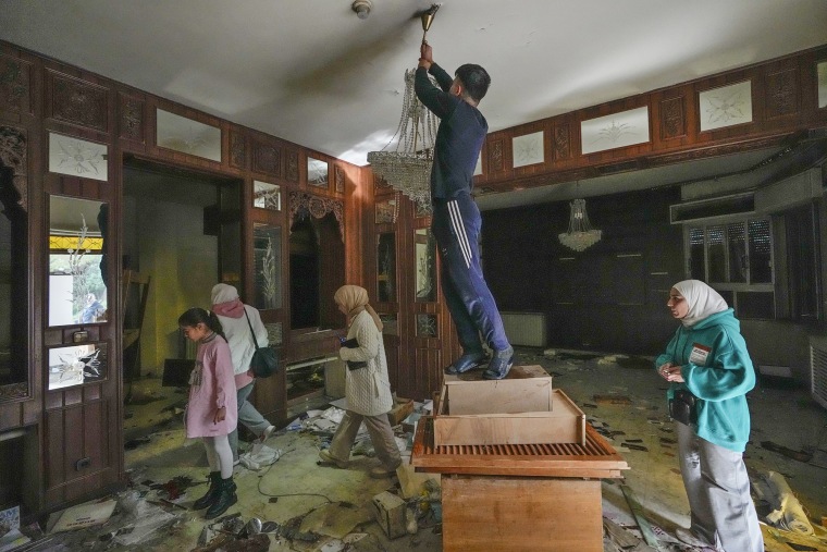 people search for belongings in the ransacked private residence of Syrian President Bashar Assad i