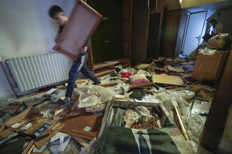 people search for belongings in the ransacked private residence of Syrian President Bashar Assad 