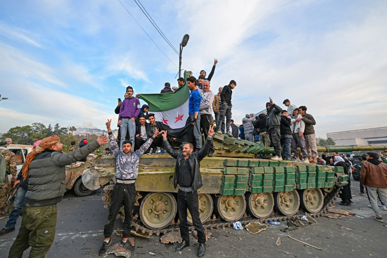 People celebrate with anti-government fighters at Umayyad Square in Damascus