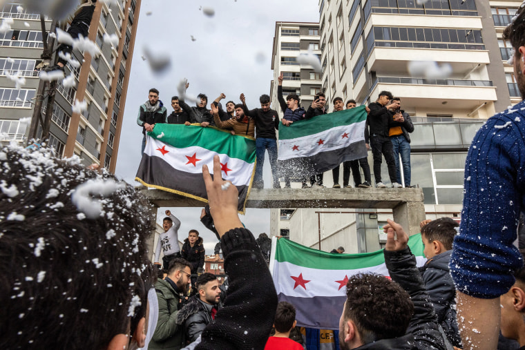 Syrians living in Turkey celebrate with opposition flags after Syrian rebels announced that they have ousted Bashar al-Assad