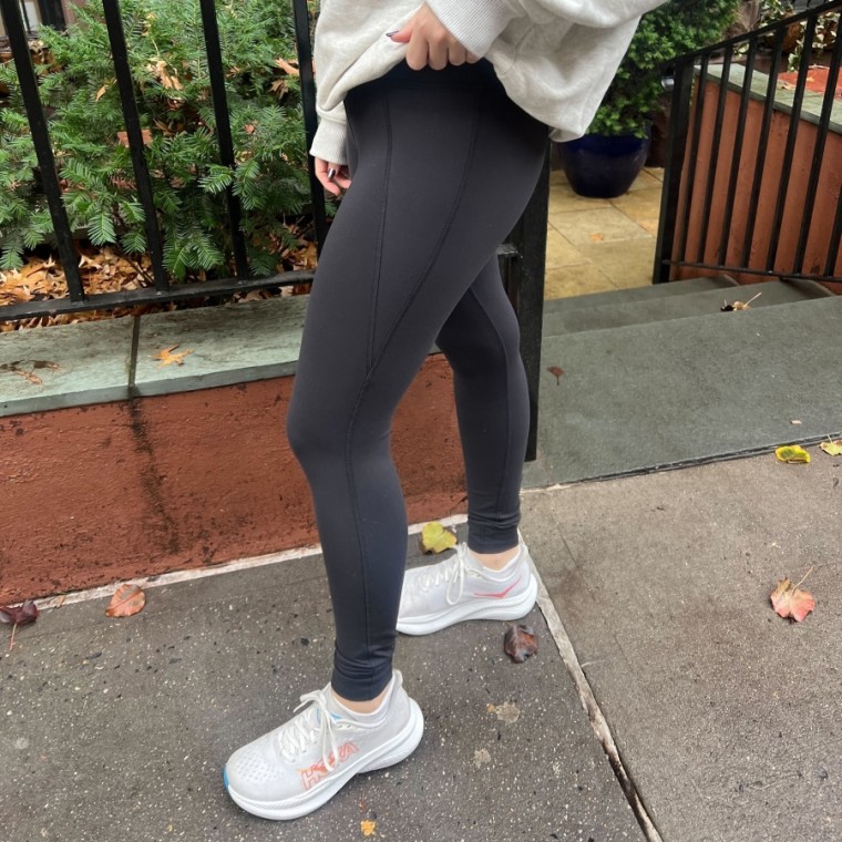 Woman wears a pair of Reebok Lux High Rise Legging while walking around.