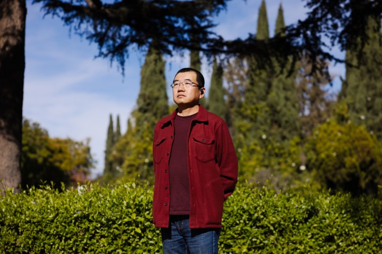 Bin Wei stands outside at a park