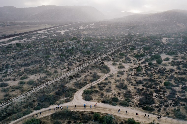 An aerial view of migrants walking through the desert