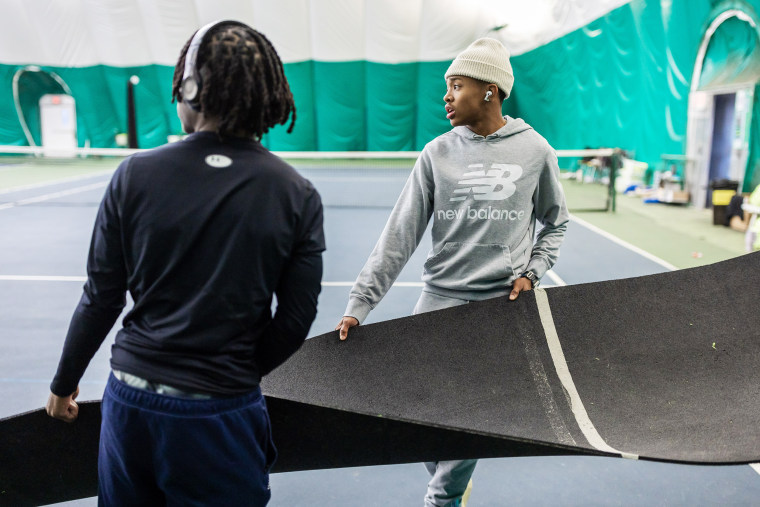 Quincy Wilson helps position a portable runway during track practice in the indoor tennis facility at the Bullis School on December 5, 2024 in Potomac, MD.