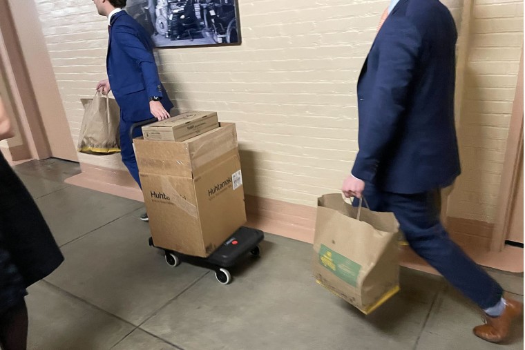 Staffers carry bags from Potbelly restaurant into a House GOP meeting at the Capitol on Dec. 20, 2024, as a shutdown looms.