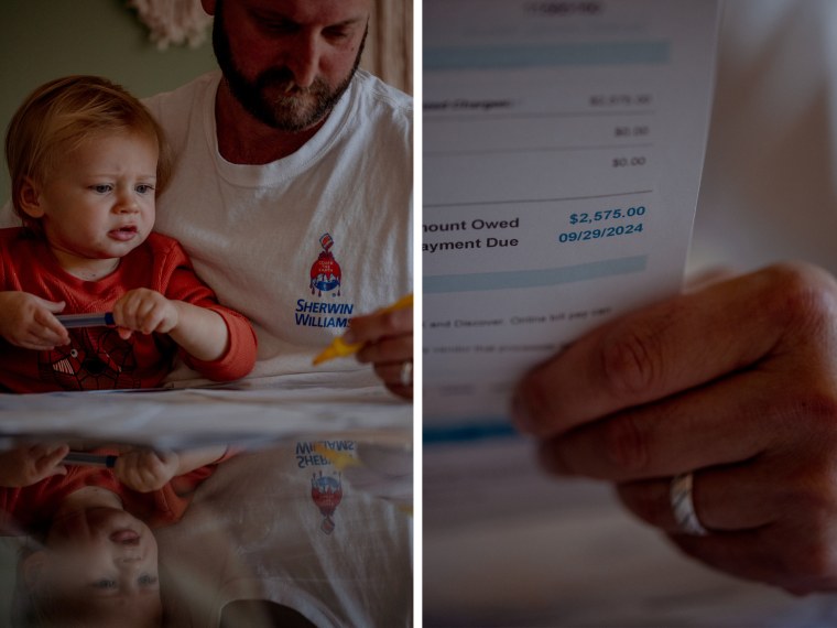 Lucas Sheffield, 2, looks on as his father, Andrew Sheffield looks at medical bills at their home 