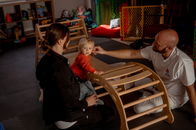 Andrew Sheffield and Rachel Kaplan play with their son, Lucas in their home in Arden, N.C., on Nov. 21, 2024. 