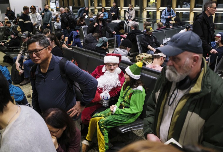 Foto: Víctor Fernández-Dávila de Nueva York, vestido como Papá Noel y un elfo, y su hija Cassandra, de 15 años, esperan para abordar un vuelo a Calgary, Alberta, para ver a su hermana en el Aeropuerto Internacional de Ottawa en Ottawa. , 20 de diciembre de 2024. 