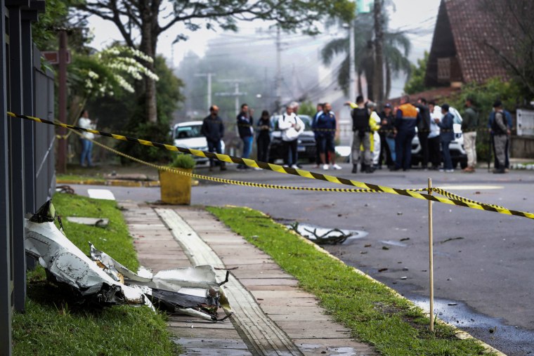 Airplane debris on the sidewalk separated by caution tape