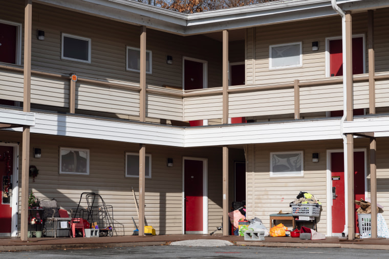 A motel with personal belongings outside doors.