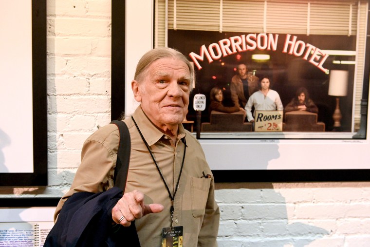 traveling Henry Diltz in front of the album cover