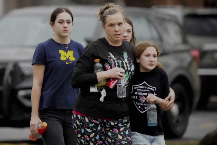 Una familia sale de la escuela cristiana Vida Abundante después de un tiroteo, el lunes 16 de diciembre de 2024, en Madison, Wisconsin.