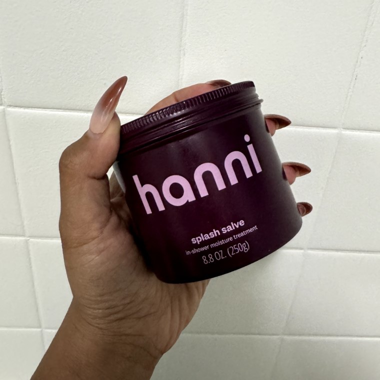 Woman holds Hanni Splash Salve in her hand.