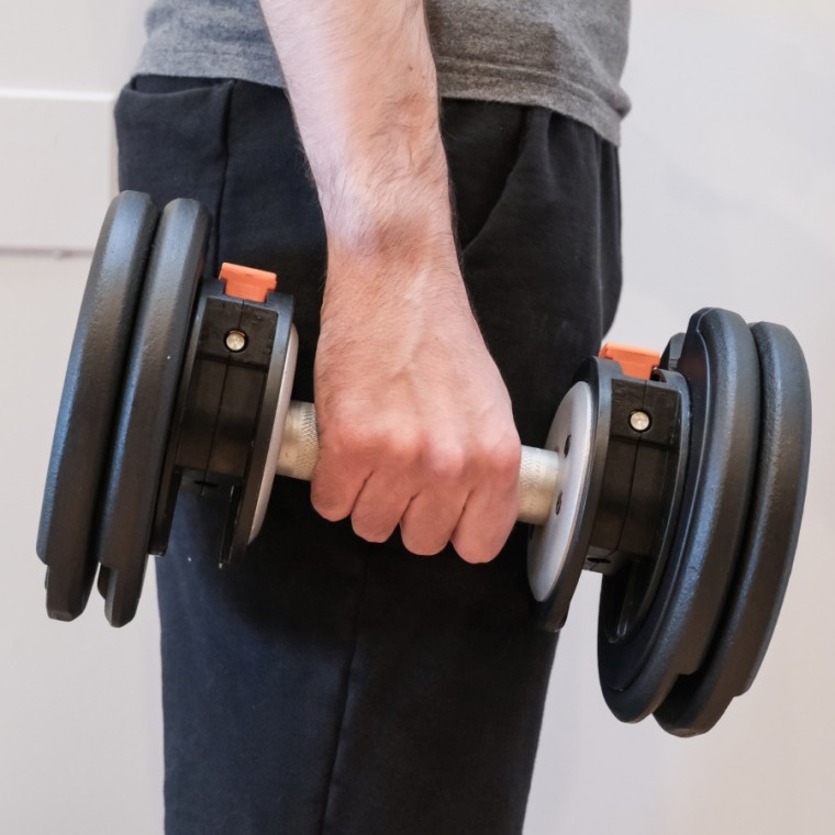 Man holding an adjustable dumbbell