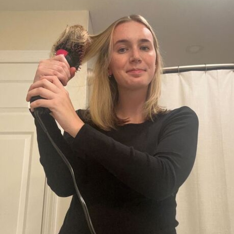 Woman dries and brushes her hair simultaneously using the Revlon One Step Volumizer Plus.