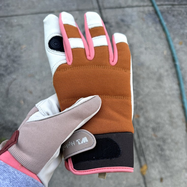 Woman wears Wells Lamont Leather Palm Work Gloves and holds the other pair in her hand.