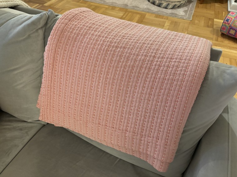 Malin and her cats love laying with the Brooklinen grid-knit throw blanket on her sofa.