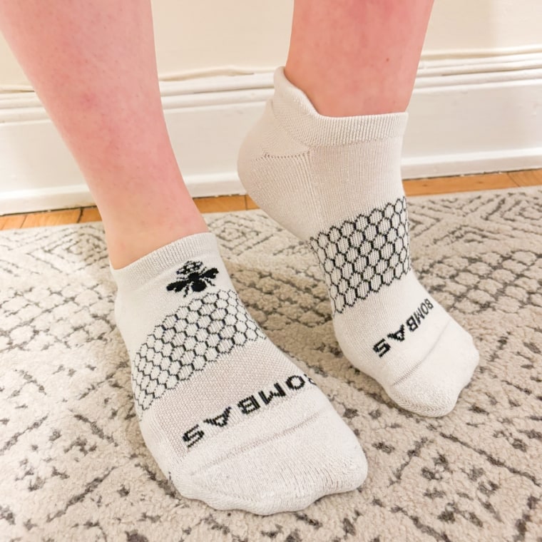 Woman wears white pair of Bombas All-Purpose Performance Ankle Socks with no shoes on