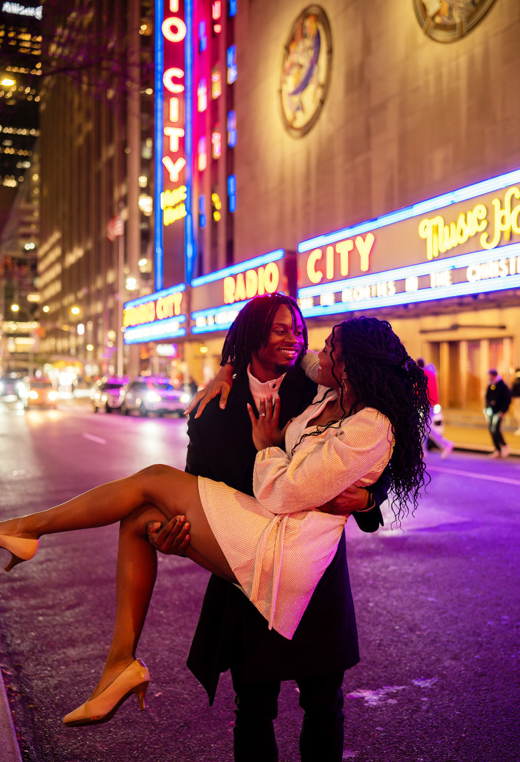 Douglas Brown and Ivana Hughes pose in front of Radio City Music Hall after getting engaged at the Rockefeller Center ice rink.