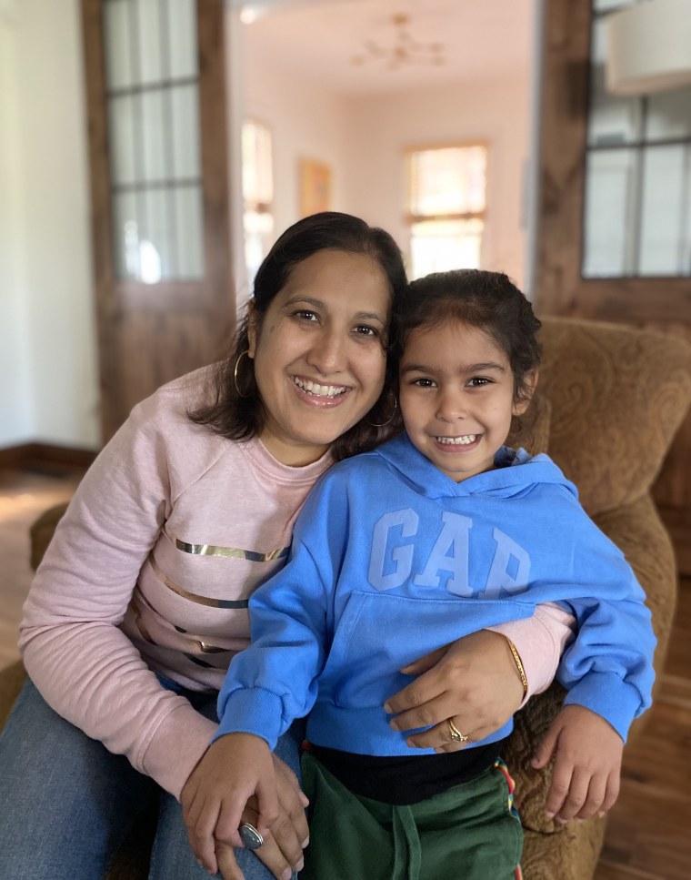 Kavita Das and her daughter, sitting on a chair.