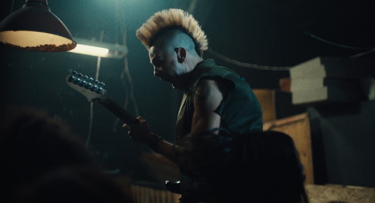 Young man with a mohawk playing a guitar, 'Los Frikis' movie still