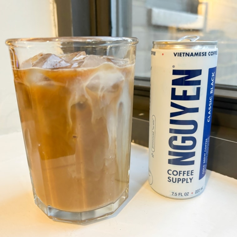 Can of Nguyen coffee next to a glass of iced coffee
