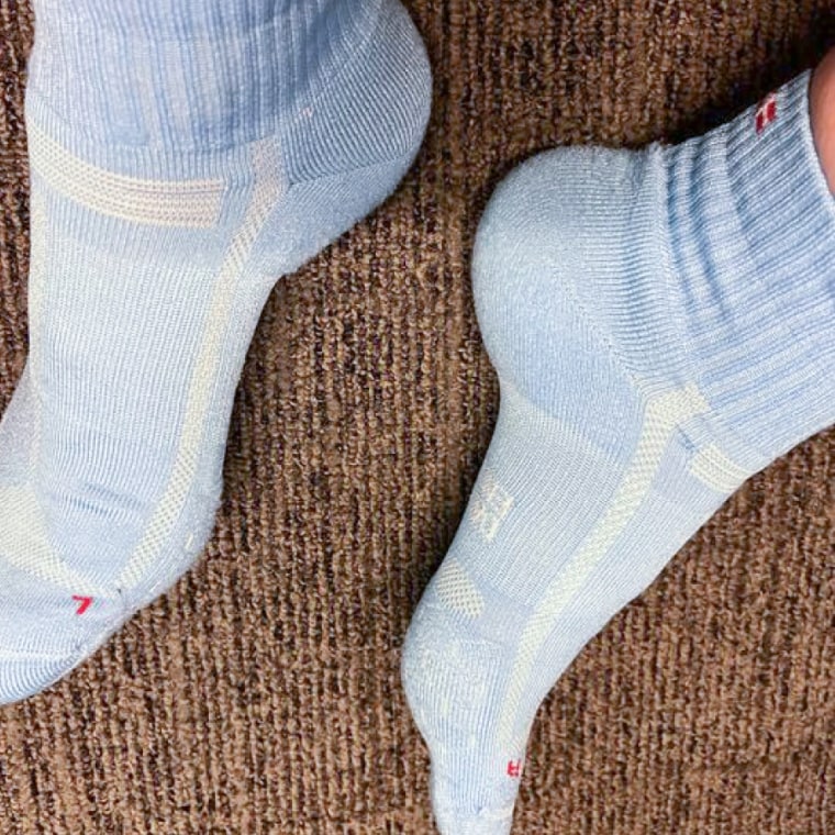 Woman wears a blue pair of the Danish Endurance Cushioned Running Socks without shoes on.