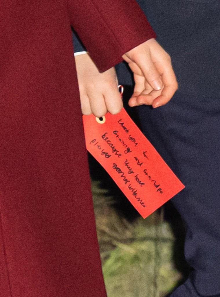 Prince Louis of Wales holds a handwritten note to his grandparents as he attends the 'Together at Christmas' service at Westminster Abbey.