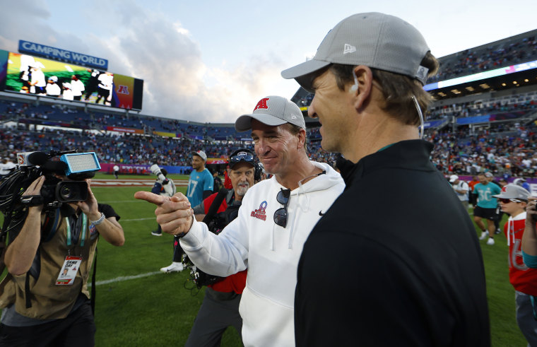 Head coach Peyton Manning of the AFC shakes hands with brother and Head coach Eli Manning of the NFC.