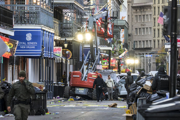 Image: Police investigators surround a white truck that crashed into a service elevator.