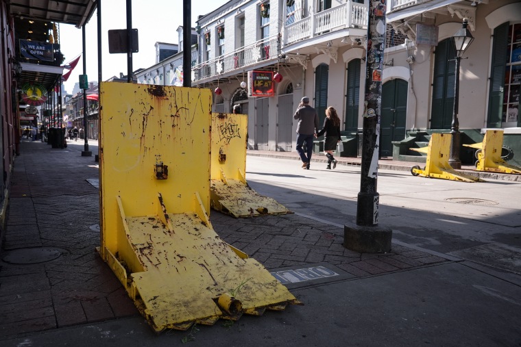 Tourist walk past temporary yellow barriers