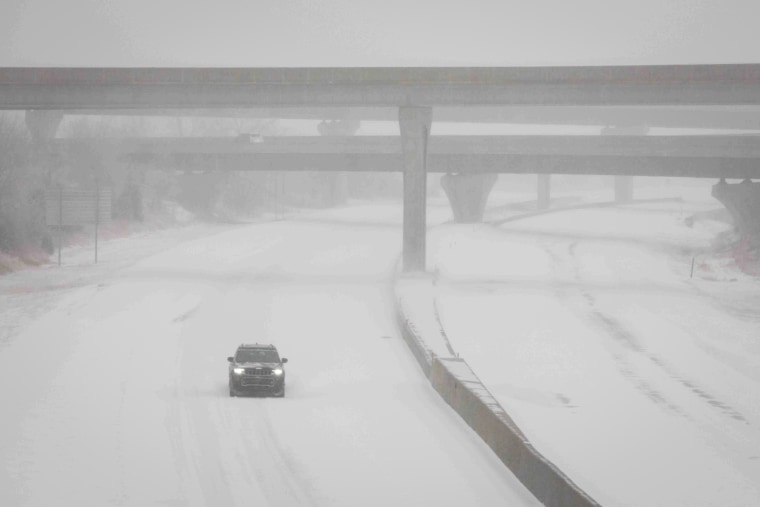 A vehicle travels westbound in blizzard conditions during a winter storm in Topeka