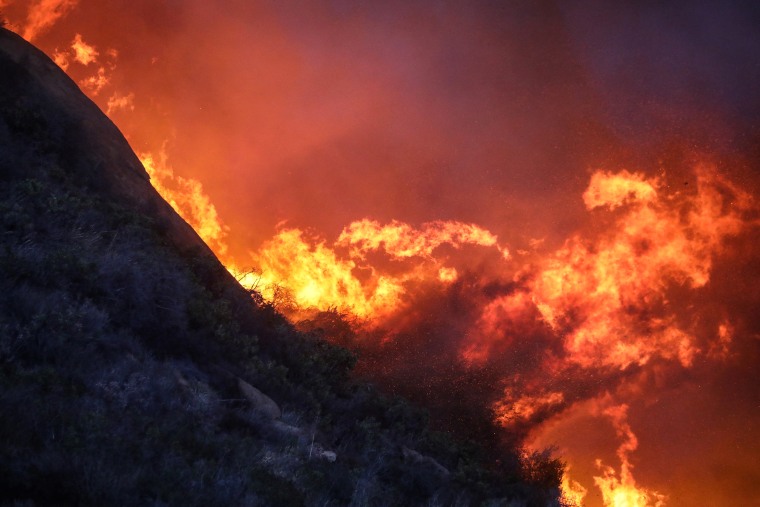  A brush fire burns near homes in Pacific Palisades