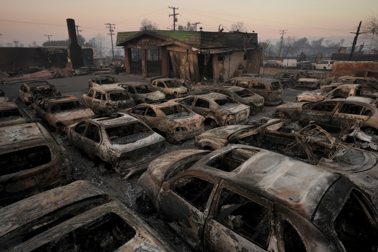 Cars are left charred inside a dealership in the aftermath of the Eaton Fire