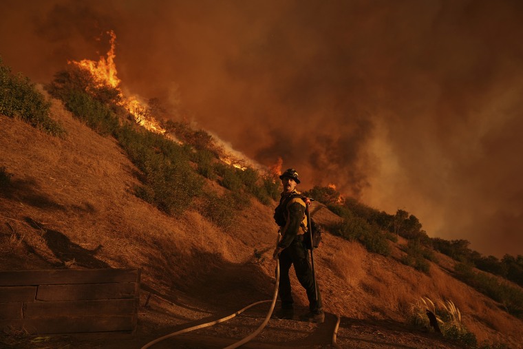 firefighters are battling a wildfire in the hills of a city