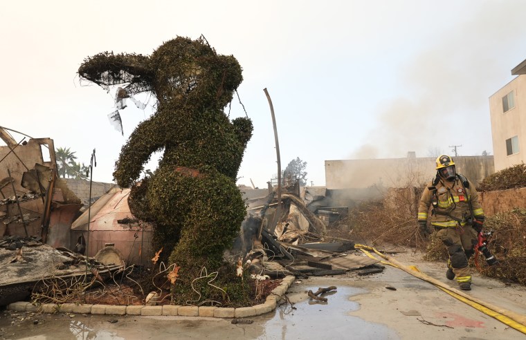 A charred bunny sculpture and rubble on a road.